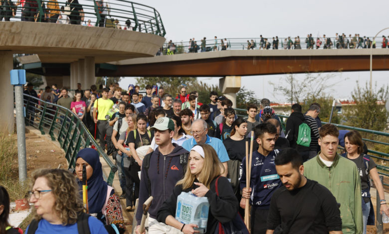 Un río de gente con cubos, escobas y agua sale a pie de Valencia para ayudar